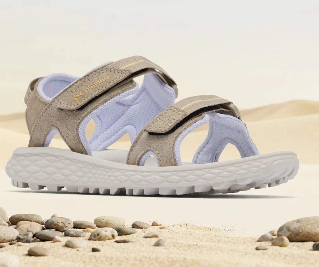 Close-up of a hiking sandal outsole showing deep traction lugs on gravel
